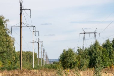 Yüksek voltajlı elektrik hatları ve mavi gökyüzündeki yüksek voltajlı elektrik iletim kulesi.