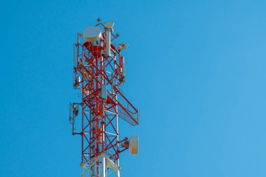 Güneşli günlerde kablosuz antenli cep telefonu kulesi. Anten Telefon ve Telekomünikasyon Kulesi 'nin mavi bir gökyüzü arkaplanı ve metin için yeri var. Arkaplan olarak kullanılabilir.