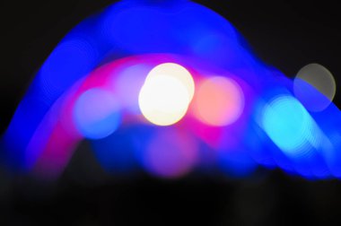 Karanlık bir arka planda bulanık Bokeh Light. Aydınlanmış bir açık hava sahnesinin Gece 'deki görüntüsü. Odaklanmamış sahne ışıkları ve konserdeki kalabalık.