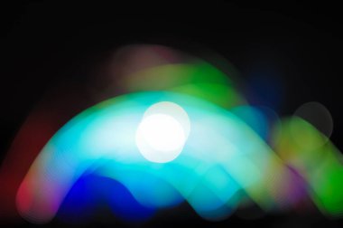 Karanlık bir arka planda bulanık Bokeh Light. Aydınlanmış bir açık hava sahnesinin Gece 'deki görüntüsü. Odaklanmamış sahne ışıkları ve konserdeki kalabalık.