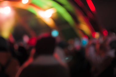 Karanlık bir arka planda bulanık Bokeh Light. Aydınlanmış bir açık hava sahnesinin Gece 'deki görüntüsü. Konserde odaksız sahne ışıkları ve kalabalık.