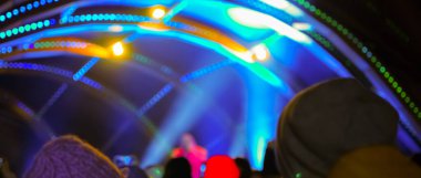 Karanlık bir arka planda bulanık Bokeh Light. Aydınlanmış bir açık hava sahnesinin Gece 'deki görüntüsü. Odaklanmamış sahne ışıkları ve konserdeki kalabalık.