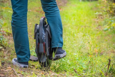 Ormandaki tek tekerlekli bisiklette insanların bacaklarının arkası.