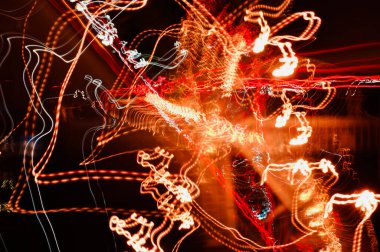 Şehir ışıklarından yüksek hızlı radyal ışık yolları ve yoldaki araba farları, gece şehrindeki otoyol, uzun pozlama, soyut kentsel arkaplan.