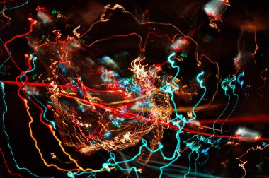 Şehir ışıklarının çok yönlü ışık yolları ve yoldaki araba farları, gece şehrindeki otoyol, uzun pozlama, soyut kentsel arkaplan.