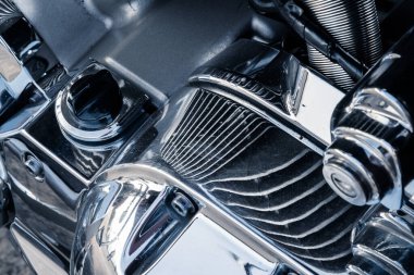 Krom kaplamalı ve yansıtıcı yüzeyli güçlü bir motor bloğunun yakın çekimi.