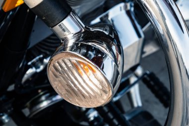 Park yerindeki motorun parlak krom yansıtıcı yüzeyine sahip güçlü bir yol motorunun farları. Küçük bir alan derinliği ve seçici bir odak noktası var..