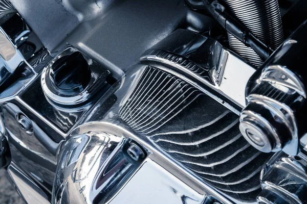 Close-up of a powerful motorcycle engine block with chrome-plated parts and reflective surfaces.