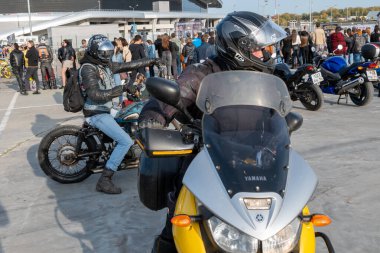 Kazan, Rusya-Eylül 2020: Motosikletliler, diğer motosikletlilerin gelişini izleyen insanların bulunduğu bir motosikletçi toplantısında, otoparkta motosikletleriyle manevra yapıyorlar.