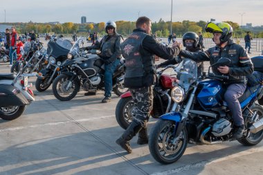 Kazan, Rusya-26 Eylül 2020: Bir motosikletçi, bir motosikletli ile birlikte şehrin sokaklarında dolaşmak için toplanan parkta enerjik bir şekilde selamlaşıyor.