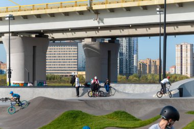 Kazan, Rusya-Eylül 2020: Kulubedeki şehir parkında, motosikletli, kaykaylı ve bisikletli koruyucu miğferli çocuklar ve gençler sürüş alanında.