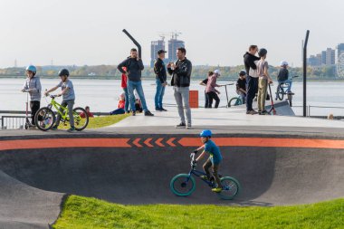 Kazan, Rusya-Eylül 2020: Şehir parkında yürüyüş yapan vatandaşlar, koruma kasklı çocuklar ve gençler, motosiklet ve motosikletli gruplar.