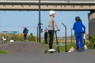 Kazan, Rusya-Eylül 2020: Şehir parkında yürüyüş yapan vatandaşlar, koruma kasklı çocuklar ve gençler, motosiklet ve motosikletli gruplar.