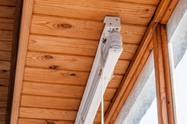 Ahşap çerçeveli tozlu pencerelerde beyaz plastik panjurlar.