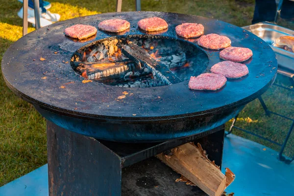 Trawniku Duży Okrągły Grill Opalany Drewnem Piecze Paszteciki Wołowe Hamburgery — Zdjęcie stockowe