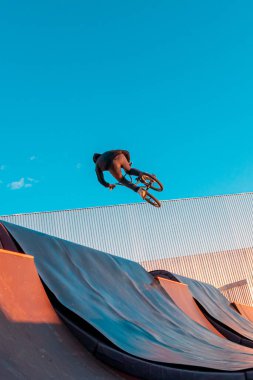 Bmx sürücüsü kaykay parkındaki rampada numara yapıyor. Spor, ekstrem sporlar, serbest stil, açık hava aktivitesi kavramı..