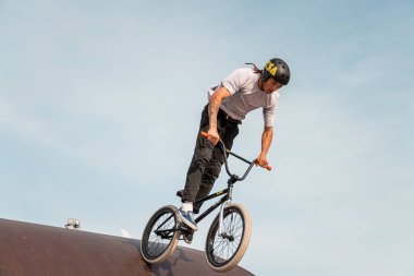 Kazan, Rusya - 26 Eylül 2020: BMX motorlu genç bir sürücü havada numaralar yapıyor. Bir kaykay parkında BMX serbest stil.