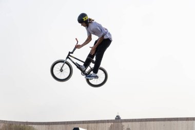 Kazan, Rusya - 26 Eylül 2020: BMX motorlu genç bir sürücü havada numaralar yapıyor. Bir kaykay parkında BMX serbest stil.