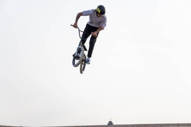 Kazan, Rusya - 26 Eylül 2020: BMX motorlu genç bir sürücü havada numaralar yapıyor. Bir kaykay parkında BMX serbest stil.