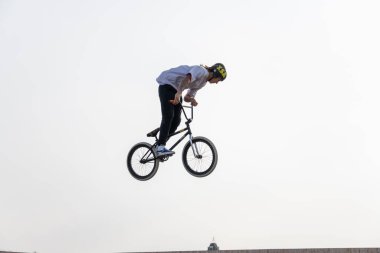 Kazan, Rusya - 26 Eylül 2020: BMX motorlu genç bir sürücü havada numaralar yapıyor. Bir kaykay parkında BMX serbest stil.