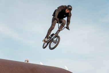 Kazan, Rusya - 26 Eylül 2020: BMX motorlu genç bir sürücü havada numaralar yapıyor. Bir kaykay parkında BMX serbest stil.