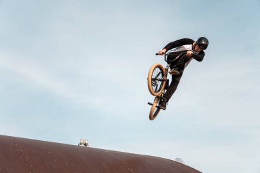 Kazan, Rusya - 26 Eylül 2020: BMX motorlu genç bir sürücü havada numaralar yapıyor. Bir kaykay parkında BMX serbest stil.