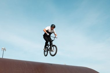 Kazan, Rusya - 26 Eylül 2020: BMX motorlu genç bir sürücü havada numaralar yapıyor. Bir kaykay parkında BMX serbest stil.