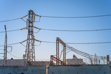 Güç hatları ve trafolar olan dağıtım elektrik santrali. Dikenli telli beton bir çit..