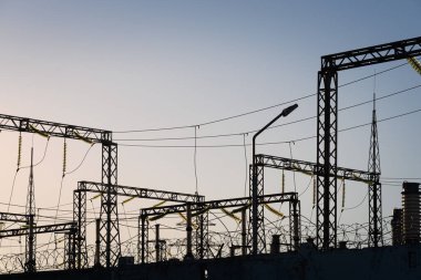 Güç hatları ve trafolar olan dağıtım elektrik santrali. Dikenli telli beton bir çit..