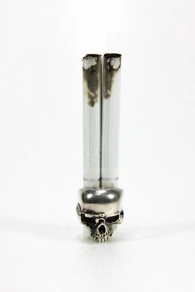 Kafatası ve beyaz arka plan üzerinde sigara.