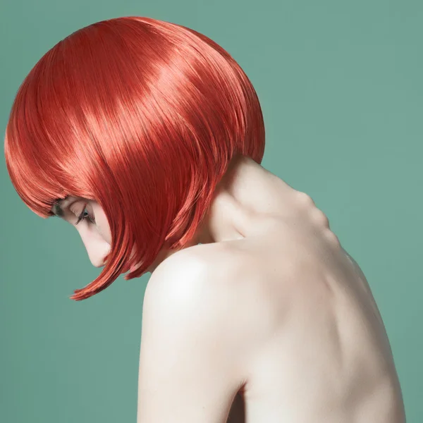 Portrait of a beautiful girl with red short hair in the studio on a green background — Stock Photo, Image