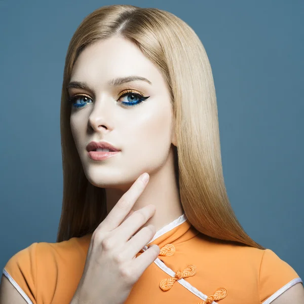 Portrait d'une belle jeune fille blonde en studio sur fond bleu, le concept de santé et de beauté — Photo