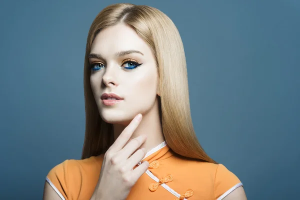 Portrait of a beautiful blonde girl in the studio on a blue background, the concept of health and beauty — Stock Photo, Image