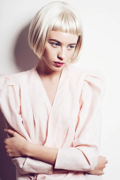 Portret van een mooie jonge blonde vrouw met kort haar in de studio op een witte achtergrond — Stockfoto