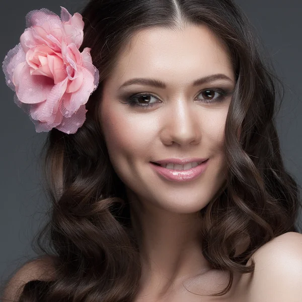 Brunette meisje met een bloem in het haar — Stockfoto