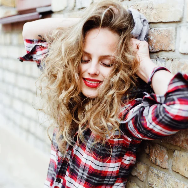 Beautiful woman posing near the brick wall — Stock Photo, Image