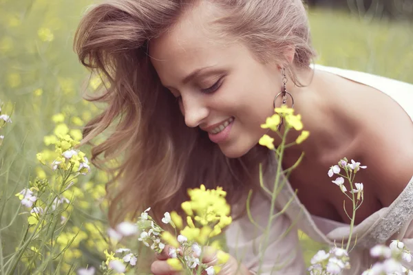 Blondin andas in doften av blommor — Stockfoto