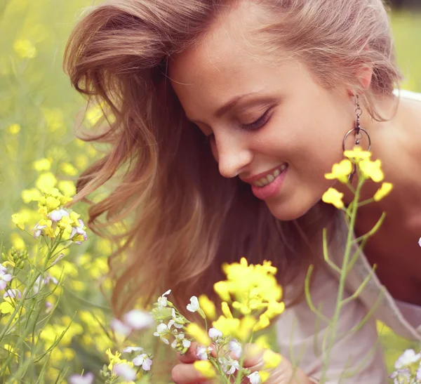 Blondýna inhaluje vůně květin — Stock fotografie