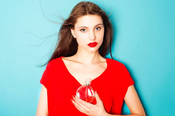 Mujer morena con una botella de perfume —  Fotos de Stock