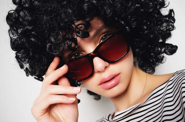 Woman in black curly wig and sunglasses — Stock Photo, Image