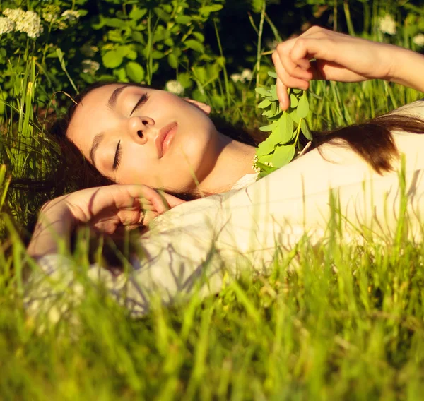 잔디에 누워 닫힌된 눈을 가진 여자 — 스톡 사진