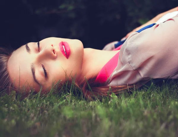 Schöne Frau im Gras liegend — Stockfoto