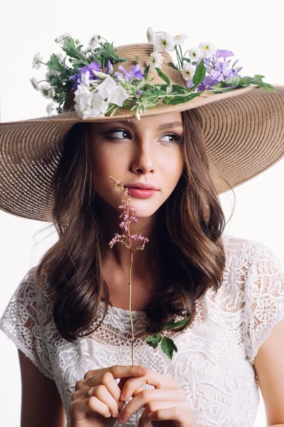 Junges Mädchen mit Hut und Blumen — Stockfoto