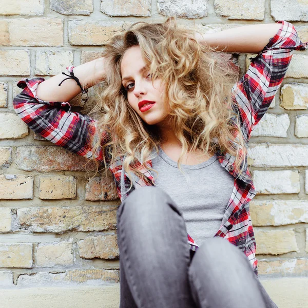 Beautiful woman posing near the brick wall — Stock Photo, Image