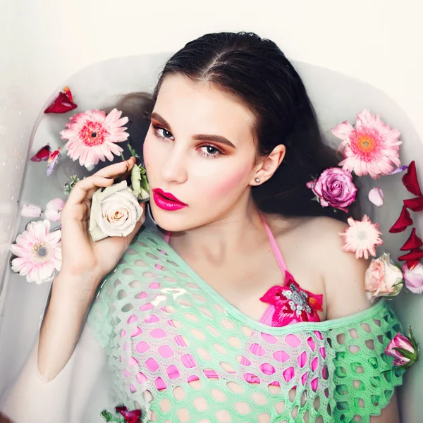 Retrato de hermosa joven morena está en el baño con flores, el concepto de salud y belleza —  Fotos de Stock