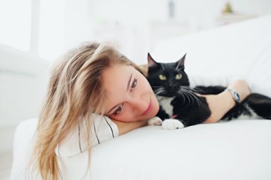 kız yatakta yatıyordu kedi ile