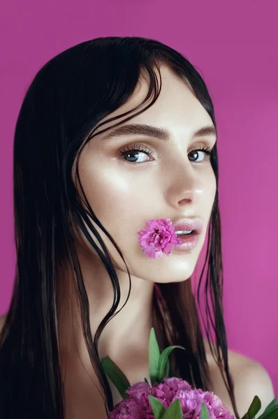 Brunette fille avec des fleurs roses — Photo