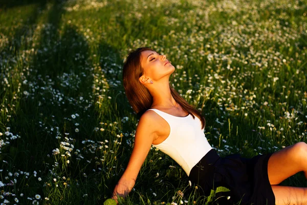 Красивая девушка, лежащая на траве — стоковое фото