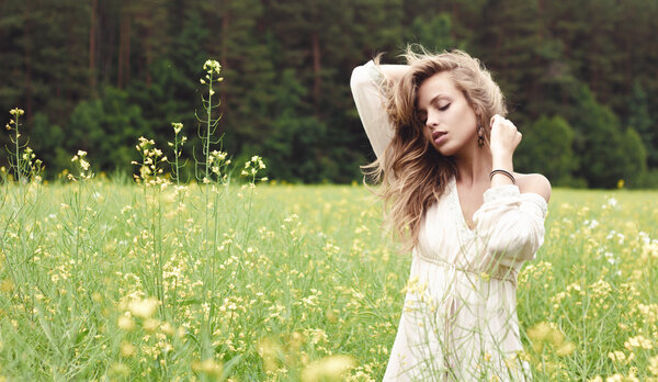 Portrait of a sexy blond girl in a field