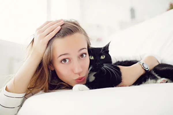 Ragazza con gatto sdraiato sul letto — Foto Stock